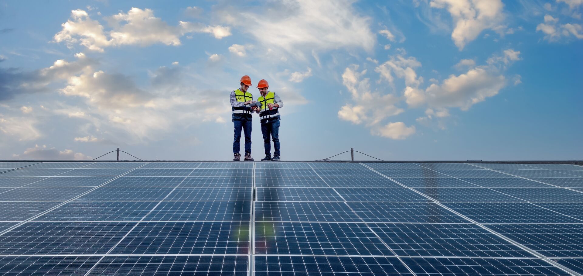 Two construction workers installing solar panels Two construction workers installing solar panels