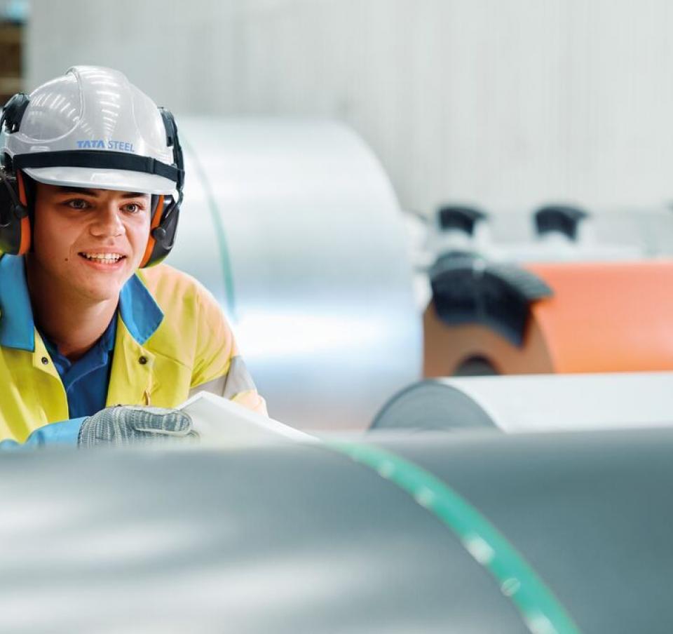 Steel worker looking at coils