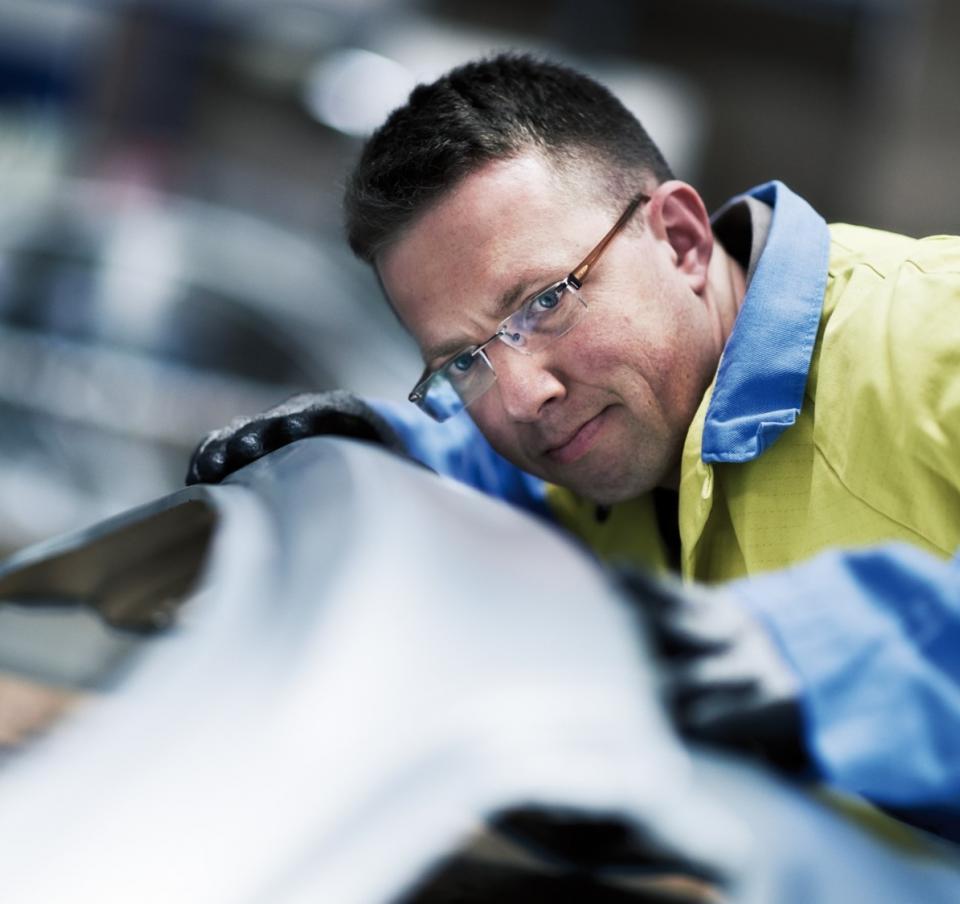 Tata Steel employee studying a piece of metal with a pensive look Tata Steel employee studying a piece of metal with a pensive look
