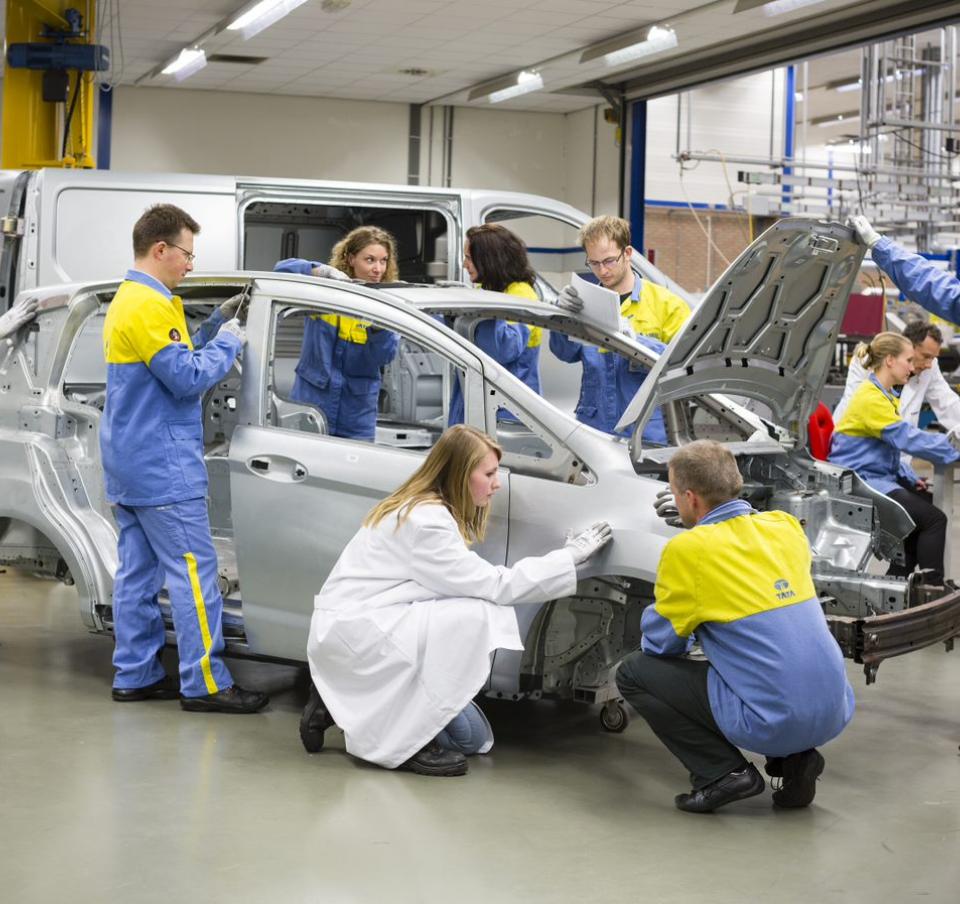 Several Tata Steel technicians working on a car frame Several Tata Steel technicians working on a car frame