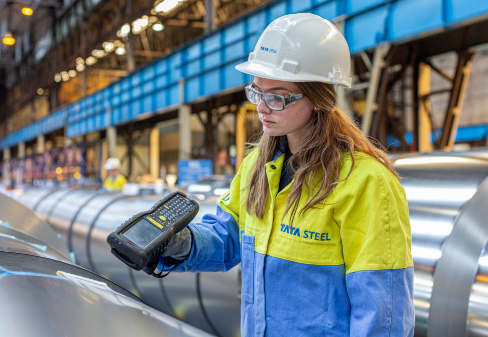 Woman in Tata Steel uniform uses a hand scanner to check coil information