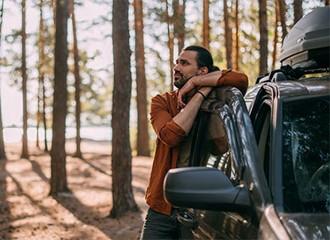 Man next to car in forest