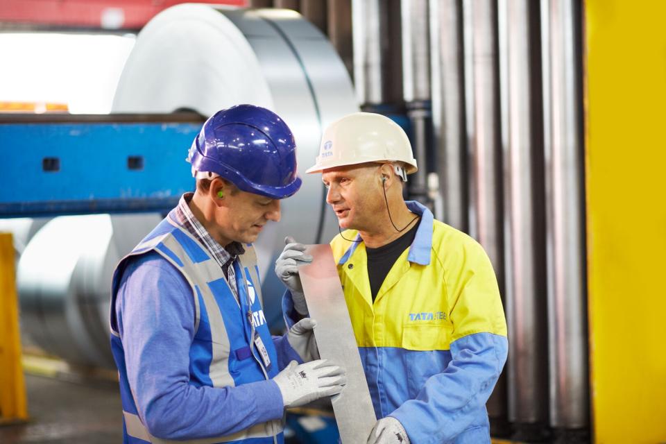 Operators examining a piece of steel
